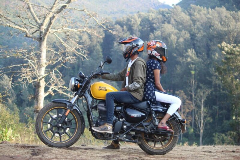 A couple on a motorcycle enjoying a peaceful ride through scenic nature, showcasing their adventurous spirit.